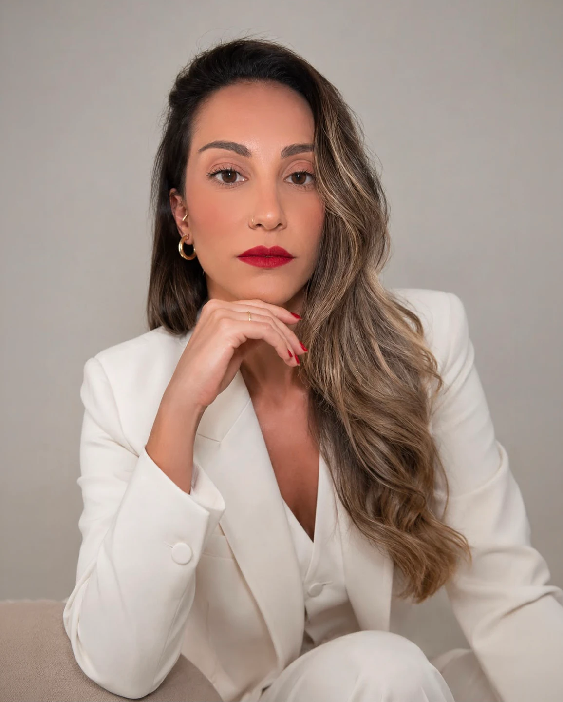 Dra. Thaís Fonseca, retrato editorial com blazer branco e fundo neutro